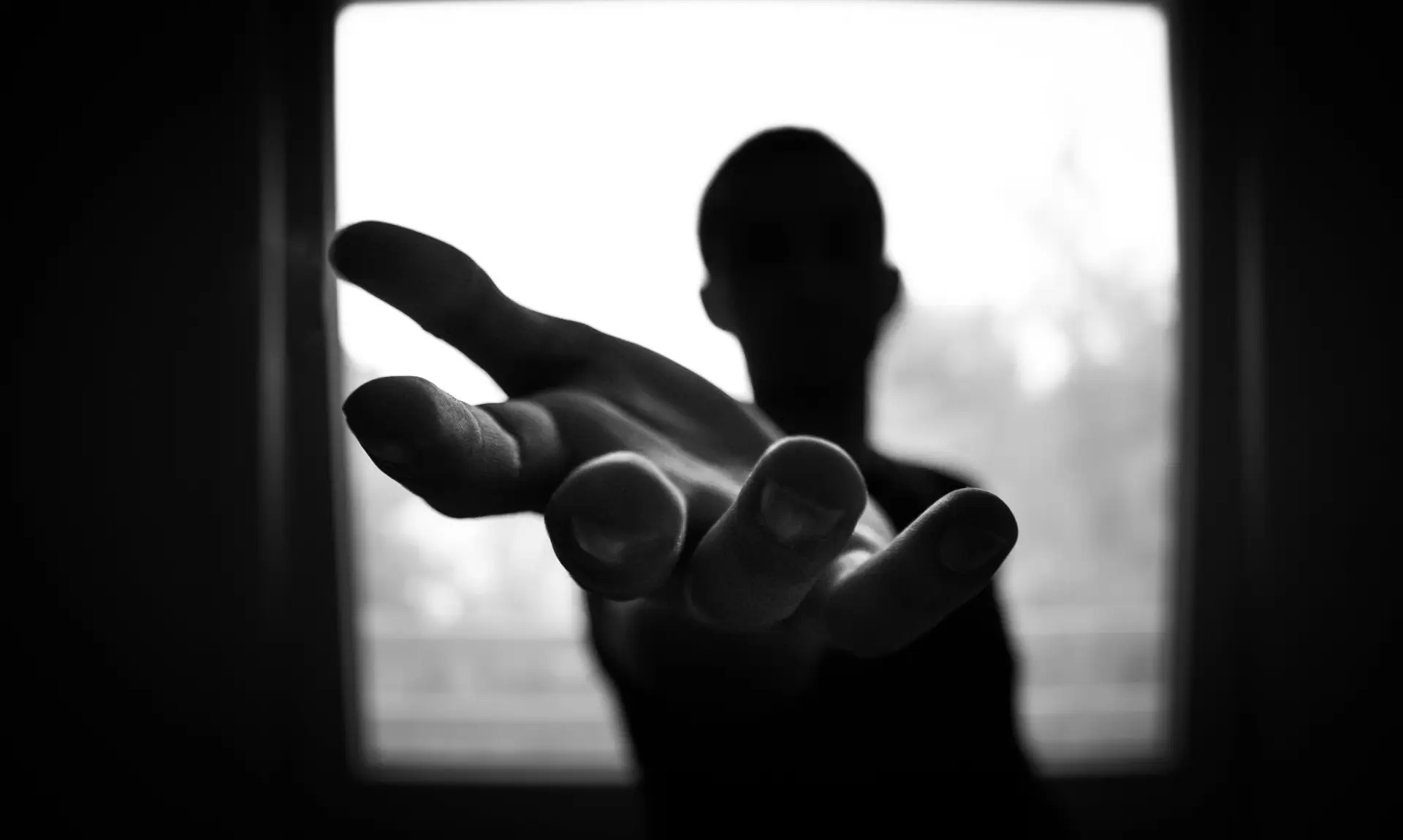 Silhouette of person holding their hand out, managing anxiety